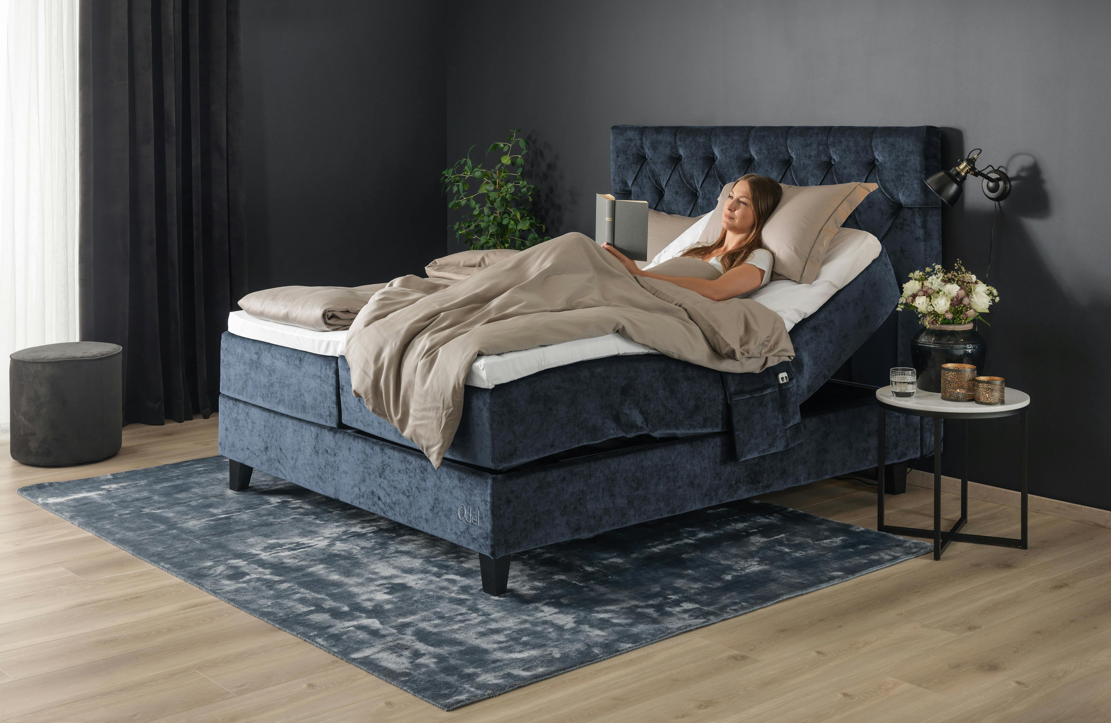 Regulerbar Odel seng fra fagmøbler med kvinne som leser bok
